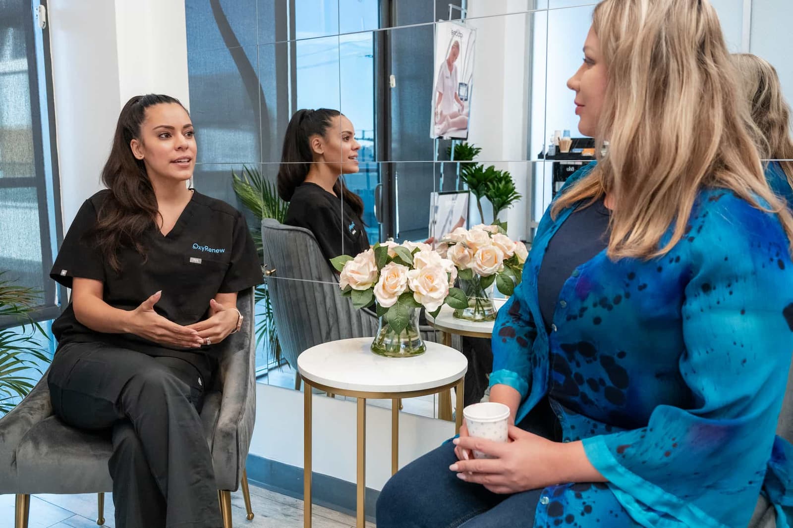 An OxyRenew staff member is speaking to a patient in the clinic's lobby.