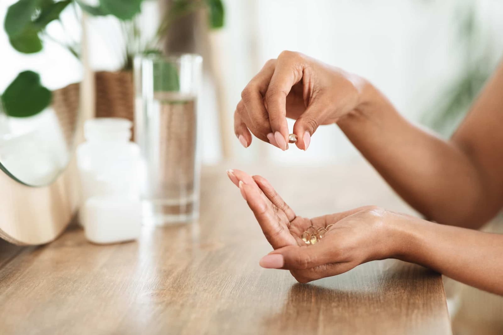 A person is holding pills in their hands.