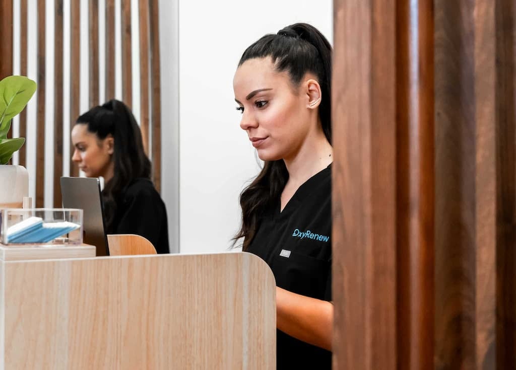 An OxyRenew employee is seen working at the front desk of the clinic.