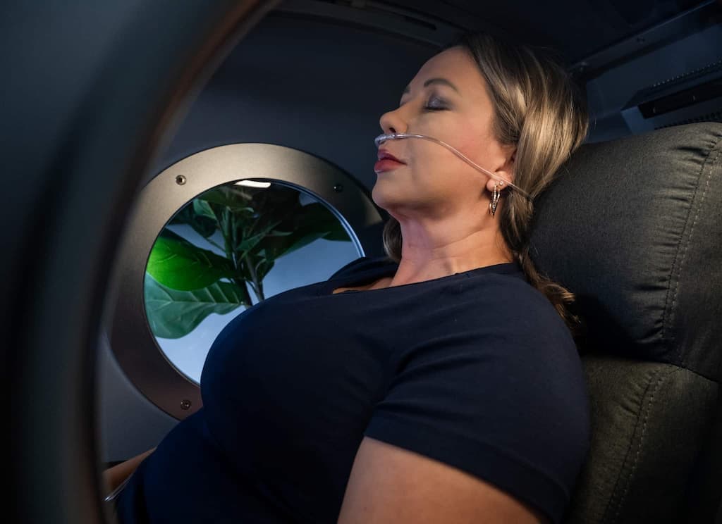 A woman is seen having a treatment inside the OxyRenew hyperbaric oxygen chamber
